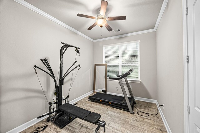 exercise area with ornamental molding, visible vents, baseboards, and wood finished floors