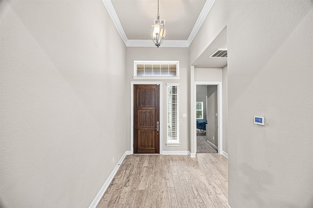 entrance foyer featuring baseboards, ornamental molding, visible vents, and light wood-style floors