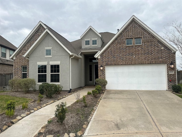 traditional-style home with a garage, driveway, brick siding, and stucco siding