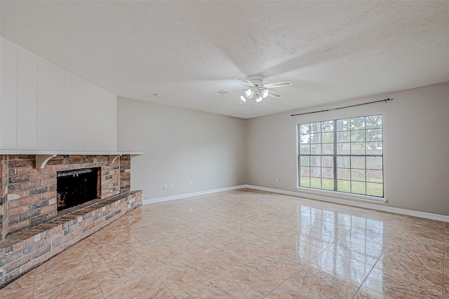 unfurnished living room with a brick fireplace, ceiling fan, a textured ceiling, and light tile patterned floors