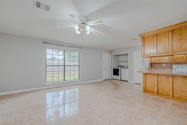 kitchen with washing machine and dryer, ceiling fan, a textured ceiling, and light tile patterned floors