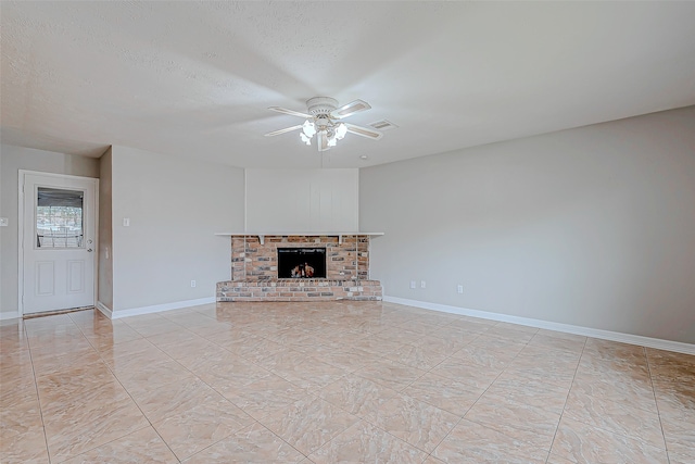 unfurnished living room featuring a textured ceiling, a fireplace, and ceiling fan