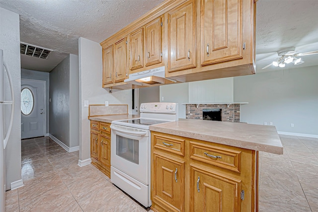 kitchen with a stone fireplace, a textured ceiling, white appliances, kitchen peninsula, and ceiling fan