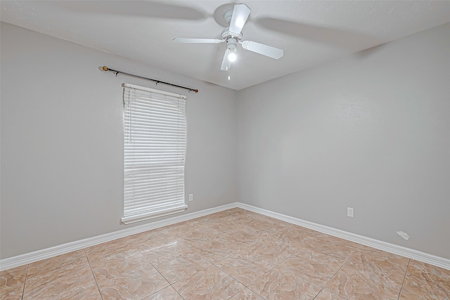 tiled spare room with ceiling fan