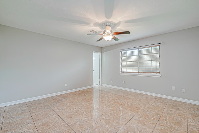 spare room featuring light tile patterned floors and ceiling fan