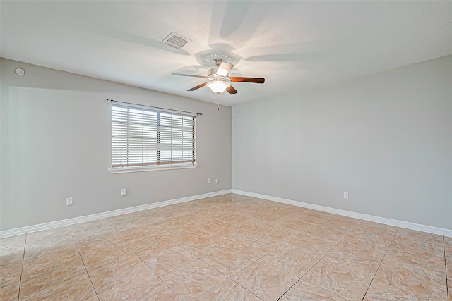 tiled spare room with ceiling fan