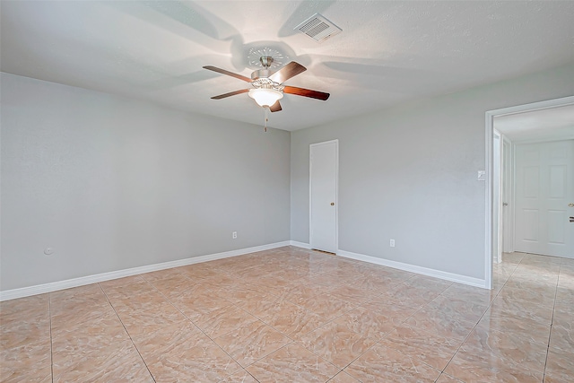 empty room featuring light tile patterned flooring, ceiling fan, and a textured ceiling