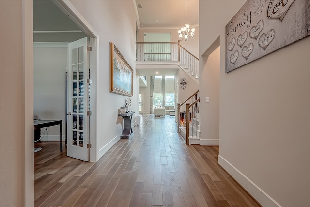 entryway with a high ceiling, a chandelier, and hardwood / wood-style floors