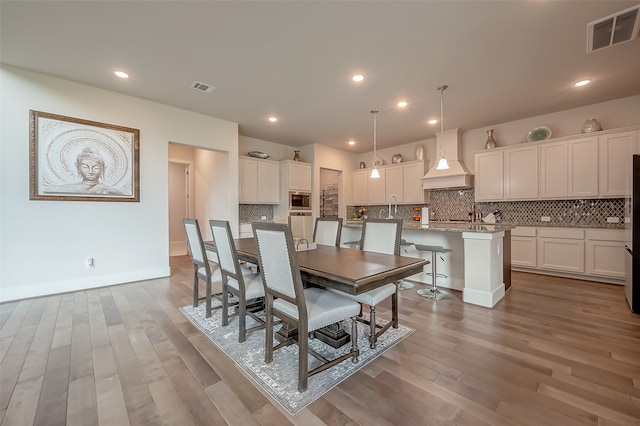 dining area featuring sink and wood-type flooring