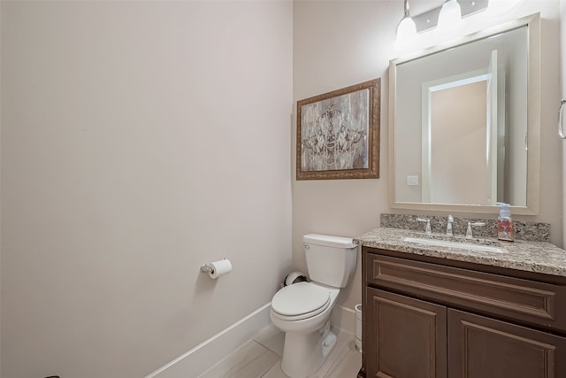 bathroom with tile patterned flooring, vanity, and toilet