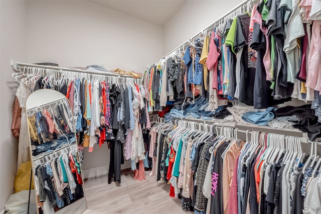 walk in closet with light hardwood / wood-style flooring