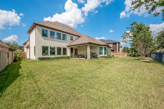 rear view of house featuring a patio area and a lawn