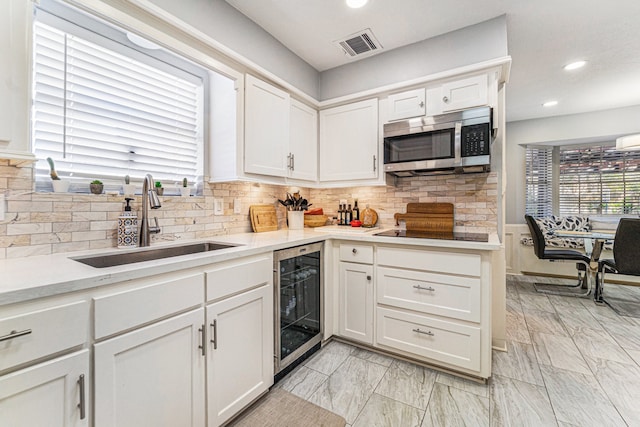 kitchen with white cabinetry, sink, beverage cooler, tasteful backsplash, and black electric stovetop