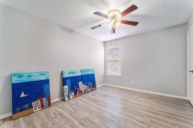 playroom featuring a textured ceiling, hardwood / wood-style flooring, and ceiling fan