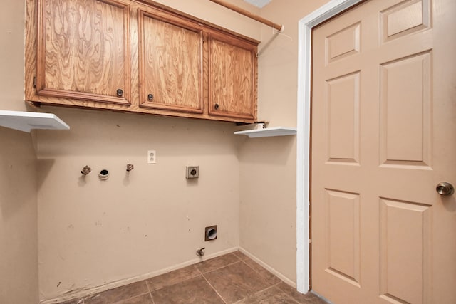 clothes washing area with washer hookup, hookup for a gas dryer, dark tile patterned flooring, cabinets, and electric dryer hookup