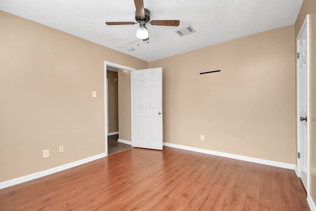 unfurnished bedroom featuring hardwood / wood-style floors, ceiling fan, and a textured ceiling