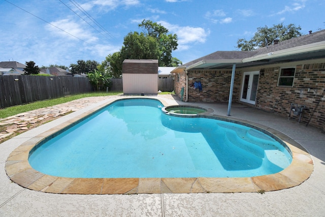 view of pool featuring a patio, a shed, and an in ground hot tub