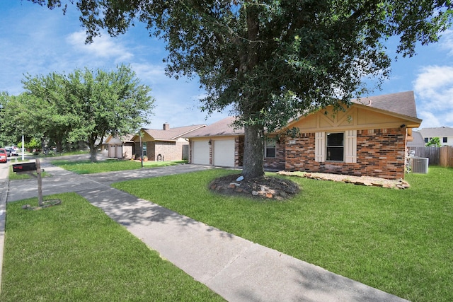 ranch-style home featuring a garage, cooling unit, and a front yard