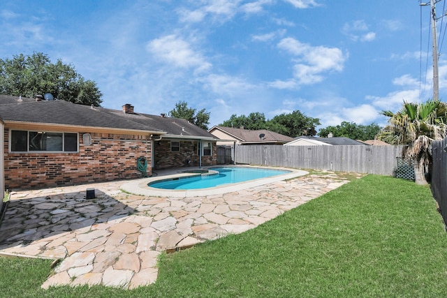 view of pool with a lawn and a patio area