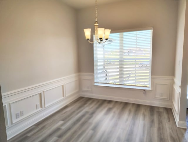 empty room featuring hardwood / wood-style flooring and a notable chandelier