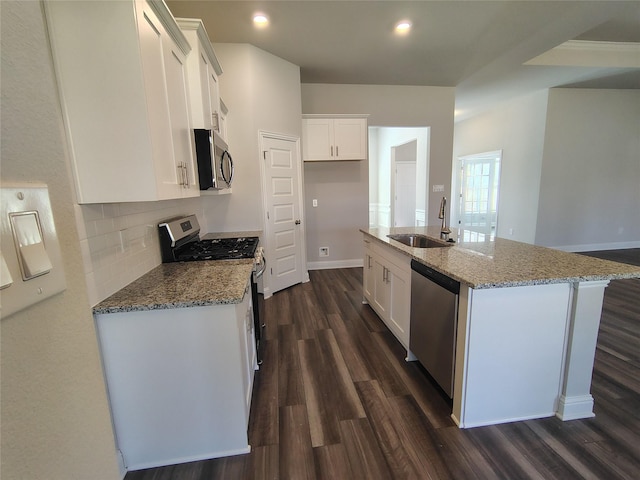 kitchen featuring light stone countertops, a sink, stainless steel appliances, dark wood-type flooring, and white cabinetry