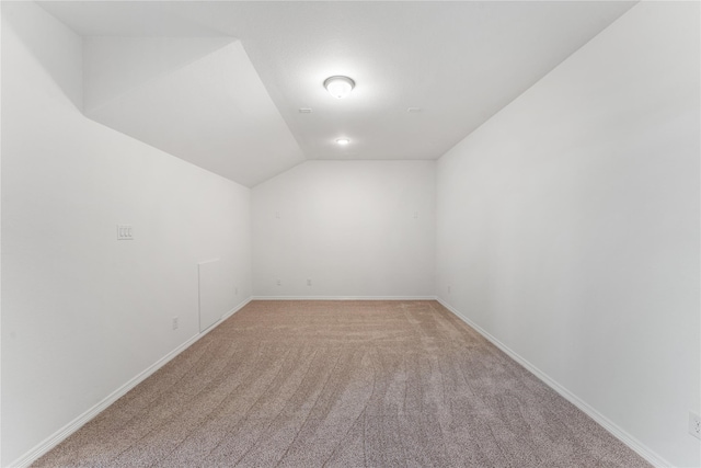 unfurnished room with lofted ceiling and light carpet