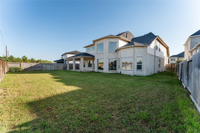 rear view of property featuring a lawn and a gazebo