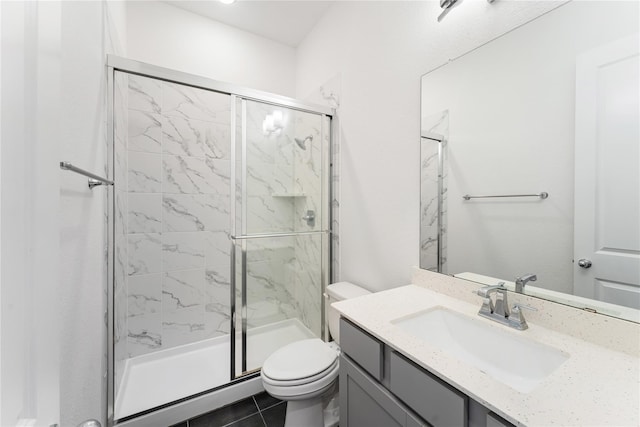 bathroom featuring toilet, vanity, an enclosed shower, and tile patterned flooring