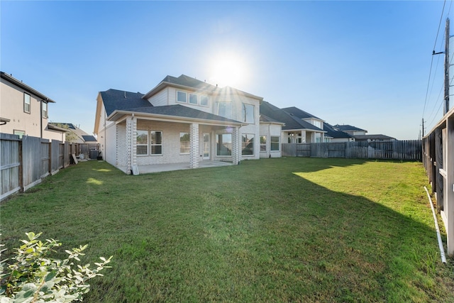 rear view of property featuring a lawn and a patio area