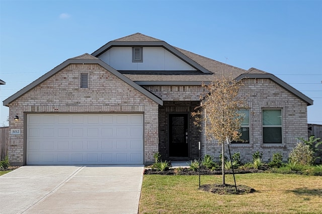 view of front of house with a front yard and a garage