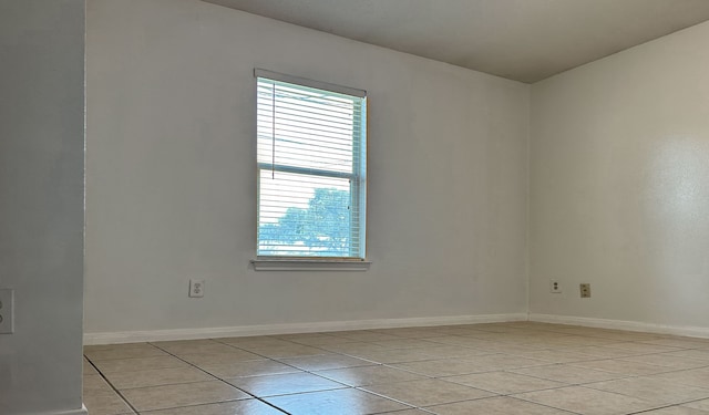 spare room with a wealth of natural light and light tile patterned floors