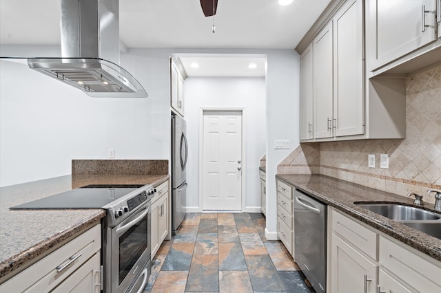 kitchen with tasteful backsplash, extractor fan, appliances with stainless steel finishes, sink, and dark stone countertops