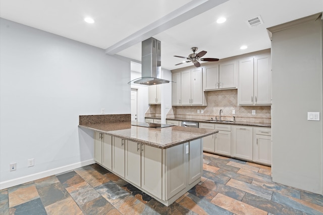 kitchen featuring island exhaust hood, backsplash, stone countertops, sink, and kitchen peninsula