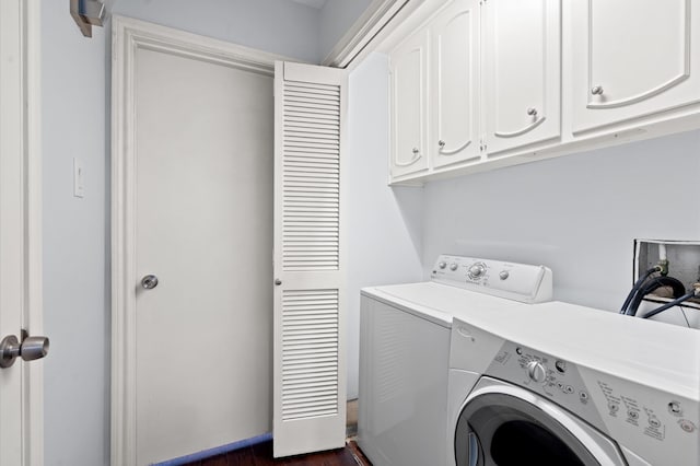 clothes washing area featuring cabinets, washing machine and dryer, and dark hardwood / wood-style flooring