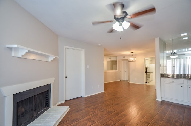 unfurnished living room with dark hardwood / wood-style floors and ceiling fan with notable chandelier