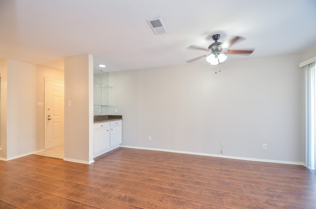 empty room with ceiling fan and dark hardwood / wood-style flooring