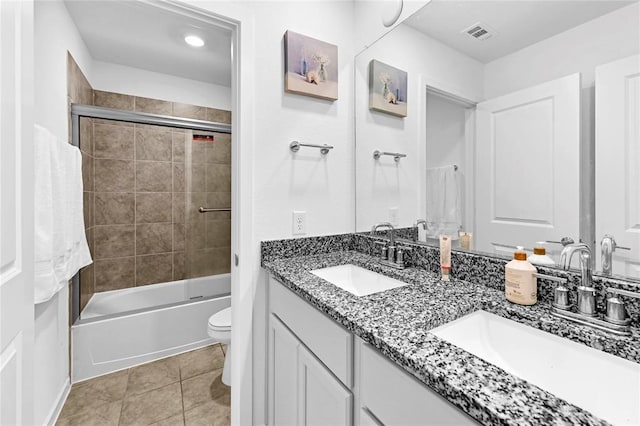 full bathroom featuring tile patterned floors, vanity, toilet, and shower / bath combination with glass door