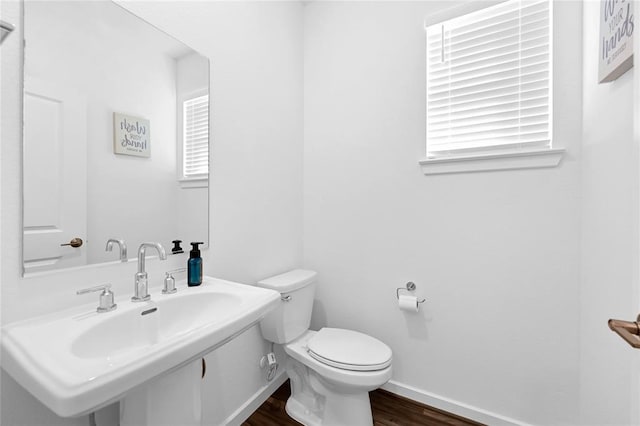 bathroom with hardwood / wood-style floors, toilet, and sink