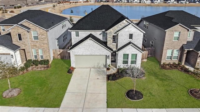 view of front facade with a water view, a garage, and a front lawn