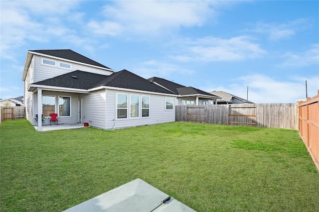 back of house with a patio area and a yard