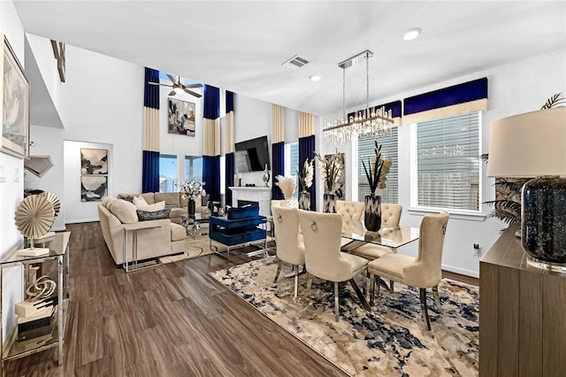 dining area featuring hardwood / wood-style floors and ceiling fan with notable chandelier