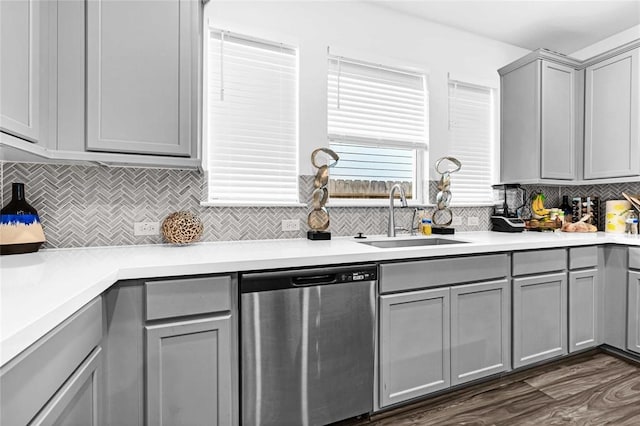 kitchen featuring tasteful backsplash, dark wood-type flooring, sink, dishwasher, and gray cabinets