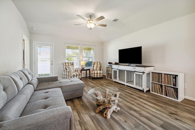 living room with hardwood / wood-style floors, ceiling fan, and vaulted ceiling