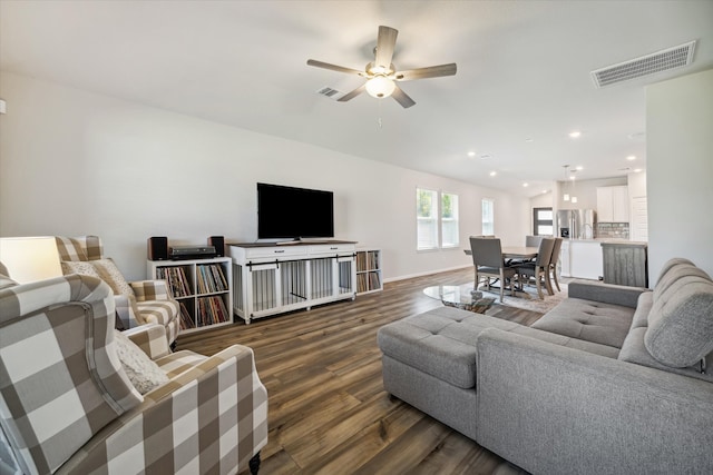 living room featuring dark wood-type flooring and ceiling fan