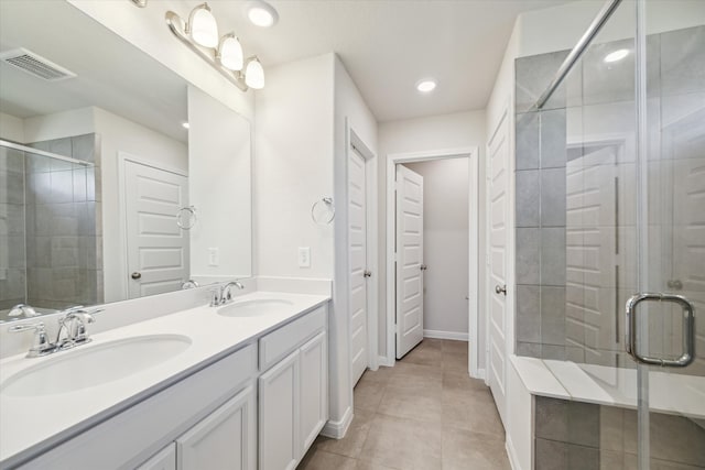 bathroom featuring walk in shower, vanity, and tile patterned flooring