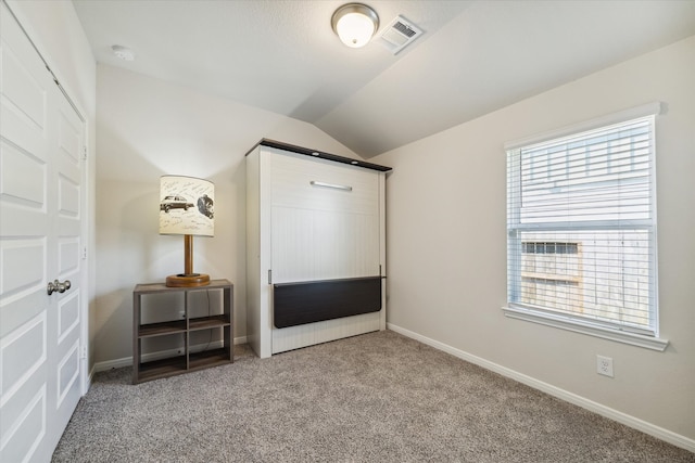 unfurnished bedroom with lofted ceiling and carpet floors