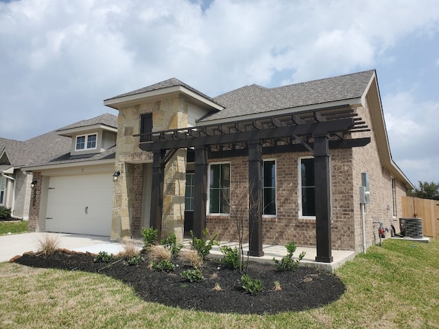 view of front facade with brick siding, central AC unit, driveway, and a garage