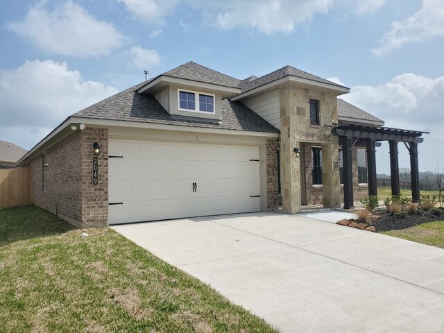 prairie-style house with driveway, a pergola, stone siding, an attached garage, and brick siding