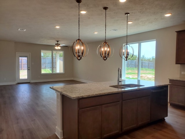 kitchen with dark wood-style floors, dishwashing machine, plenty of natural light, and a sink