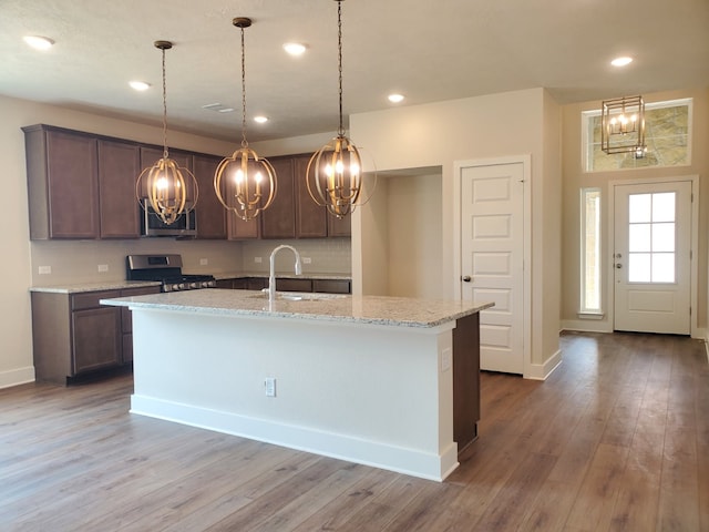 kitchen featuring recessed lighting, appliances with stainless steel finishes, wood finished floors, and a sink